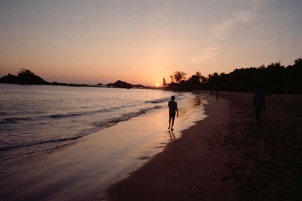 Om Beach, Gokarna, Karnataka. Solen er på vej ned over Om Beach. Ser man stranden for luften, er den formet som det karakteristiske indisk ’Om’-tegn. Det er som tre små strande i én, med hostels og restauranter langs hele promenaden. Stemningen er afslappet med lejrbål på stranden, når mørket falder på. 