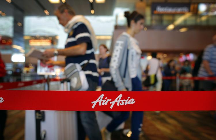 Internationalt. Passagerer står i kø ved AirAsias check-in i lufthavnen i Singapore. Selskabets fly QZ8501 forsvandt søndag. 