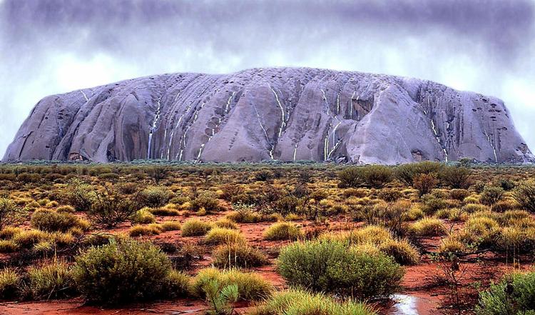 REJSEMÅL. Australien lokker mange turister til sine attraktioner som her Ayers Rock/Uluru. Men nogle tilrejsende fra især Sverige og Tyskland udnytter hjælpeorganisationer for at strække pengene under turen down under. 