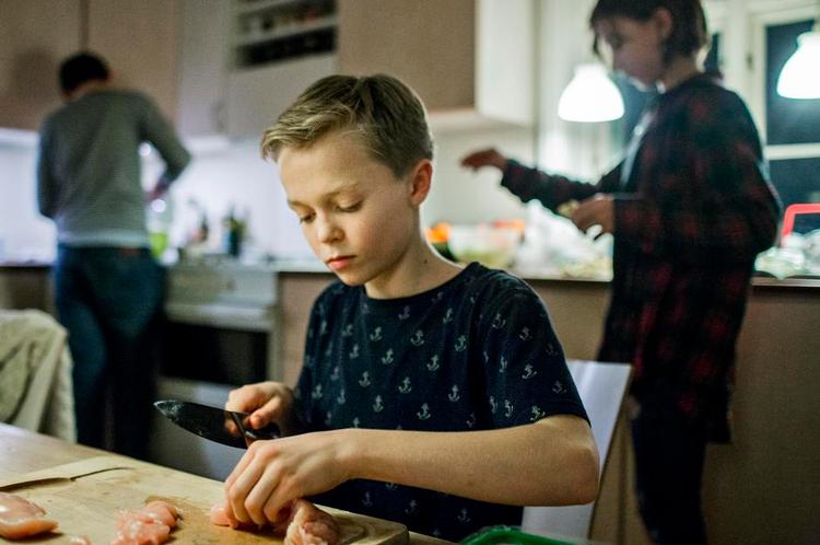 Tre kokke og en hund. Alfred Røn Strand (til venstre) ordner kagedejen, mens Peter Nygaard skærer kylling i tern, og Agnes Bjørn Jensen betænker hunden Ziggy med flyvende gulerodsstykker. 