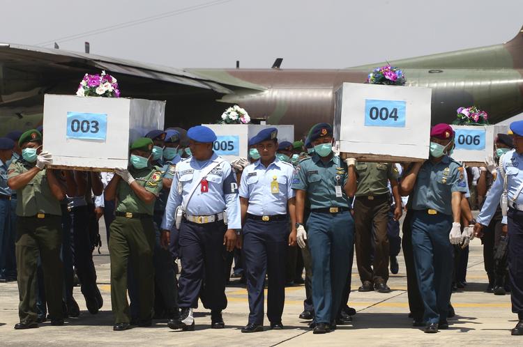 omkomne. Indonesiske soldater bærer kister med omkomne efter flyulykken i dag. 