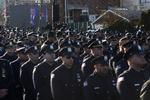 KOLDFRONT. Politibetjente vender ryggen til New Yorks borgmester Bill de Blasio, da han toner frem på storskærm under tale ved myrdet politimands begravelse. 
