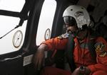 Redning. En pilot i en indonesisk militær-helikopter spejder efter vragdele og andre spor efter det forsvundne AirAsia-fly. 