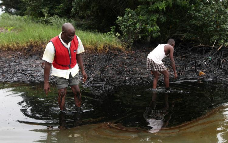 Forurenet. Lokale beboere vader i 2010 gennem en oliepøl, der har samlet sig i en bæk nær Landsbyen Bodo I Nigeria. 