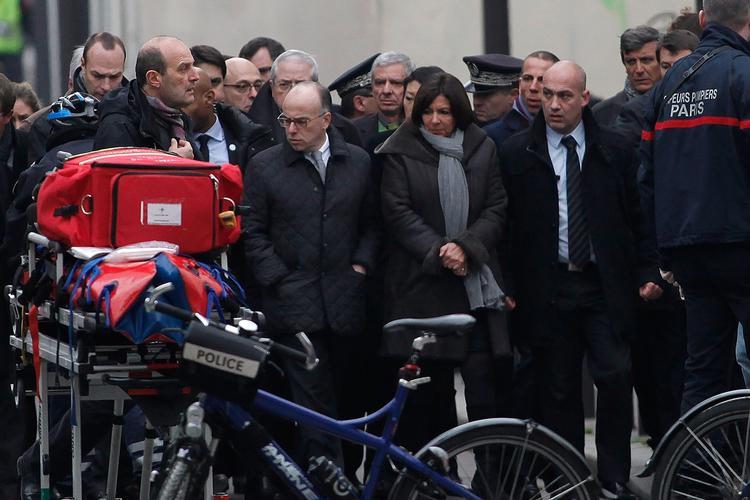 Chok. Frankrigs indenrigsminister Bernard Cazeneuve (i midten tv) og borgmester i Paris Anne Hidal ankommer til det franske ugeblad Charlie Hebdo, der i dag var genstand for et blodigt terrorangreb. 
