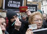 Sørgedag. Franske journalister markerer den nationale sørgedag ved at samle sig foran Charlie Hebdo. Her viser de deres pressekort og løfter blyanten op for at kæmpe for ytringsfriheden 