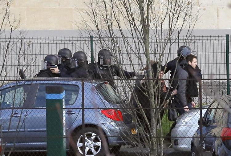 Politiet tager opstilling ved et jødisk supermarked, hvor en mand holder flere personer som gidsler. 