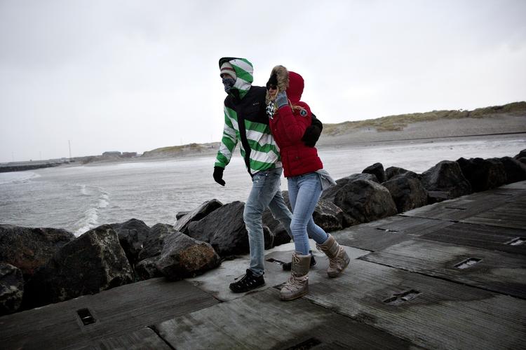NAVNELEG. Gårsdagens storm fik navnet Dagmar. I den hedder den Egon. Stormen Dagmar ramte Vestkysten ved middagstid i går. To tyske turister er på gåtur på molen i Hvide Sande. 