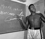 selvbevidst. Muhammed Ali i 1962 på vej mod den absolutte boksetop under navnet Cassius Clay forudser på en tavle, at hans næste kamp bliver afgjort på knockout i fjerde runde - og det gjorde den, da Archie Moore blev slået i gulvet. 