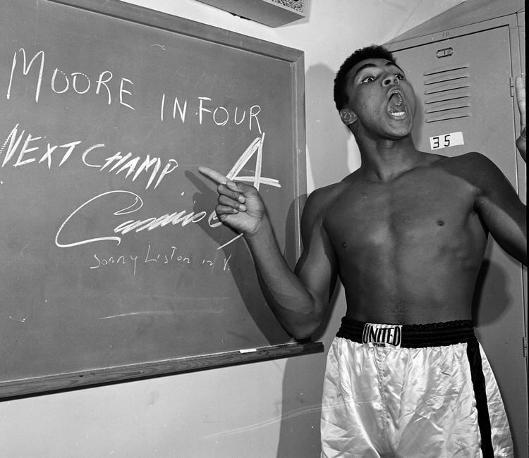 selvbevidst. Muhammed Ali i 1962 på vej mod den absolutte boksetop under navnet Cassius Clay forudser på en tavle, at hans næste kamp bliver afgjort på knockout i fjerde runde - og det gjorde den, da Archie Moore blev slået i gulvet. 