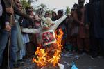 Demonstranter i den pakistanske by er i gang med at brænde et billede af den franske præsident François Hollande i protest over magasinet Charlie Hebdos forside. 