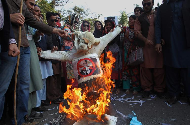 Demonstranter i den pakistanske by er i gang med at brænde et billede af den franske præsident François Hollande i protest over magasinet Charlie Hebdos forside. 