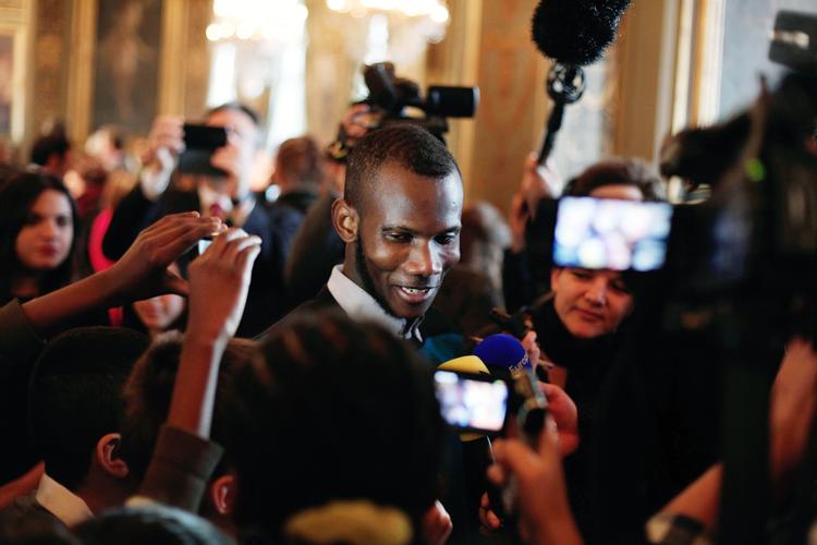 Frankrig. Lassana Bathily taler med en gruppe børn ved en ceremoni i Paris, hvor også USA's udenrigsminister John Kerry og Paris' borgmester, Anne Hidalgo, deltager. 