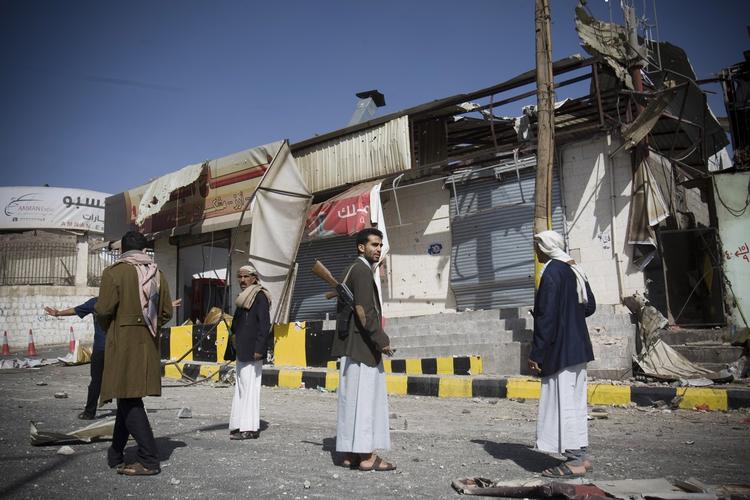 Stormløb. Houthi-militsen i Yemen har stormet præsidentpaladset her til aften. På billedet ses krigere fra militsen, som holder vagt ved nogle ødelagte bygninger. 