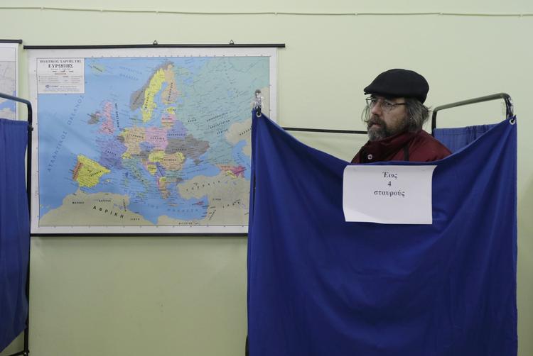 STEMMEAFGIVNING. Vælger i Athen sætter sit kryds. 
