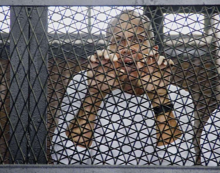 Fri. Journalisten Peter Greste, der her ses bag tremmer under et retsmøde i Kairo, er blevet sat fri fra egyptisk fængsel. 