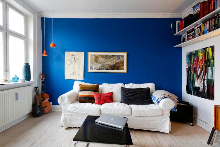 Markant. Ikea-sofaen står på kongeblå baggrund. Orange matcher det godt, og Trine Kjærhauge har selv spraymalet den ene 1970’er-lampe, som oprindeligt var hvid. 