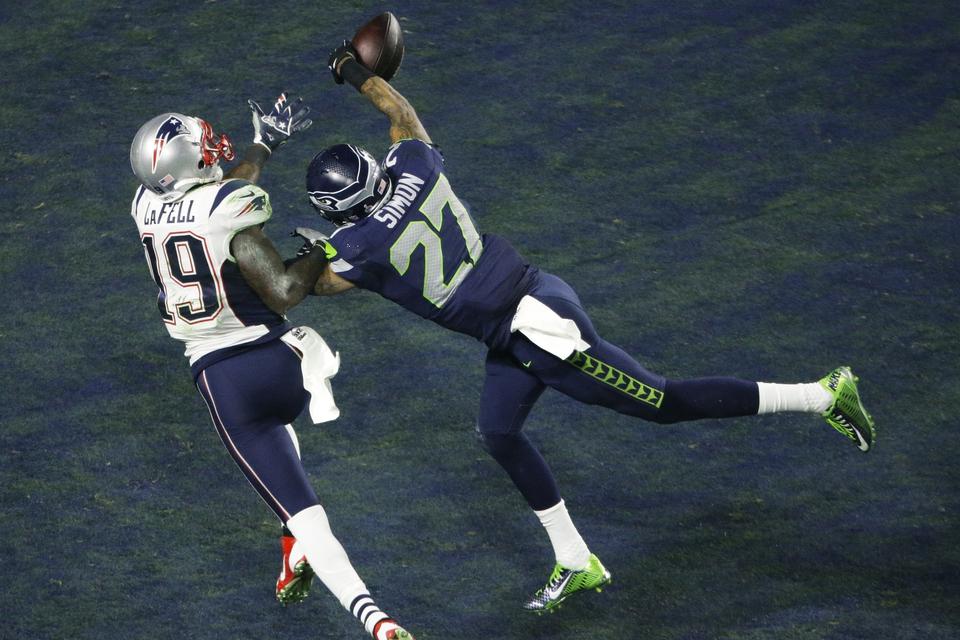 Seattle Seahawks Tharold Simon bryder en aflevering til New England Patriots Brandon LaFel. 