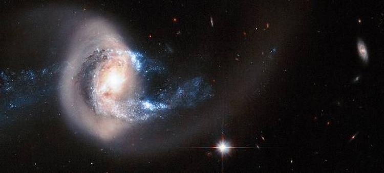GALAKSEKAMP. NGC 7714 har to lange haler af stjerner og en sky af stof, den tiltrækker fra sin nabo. 