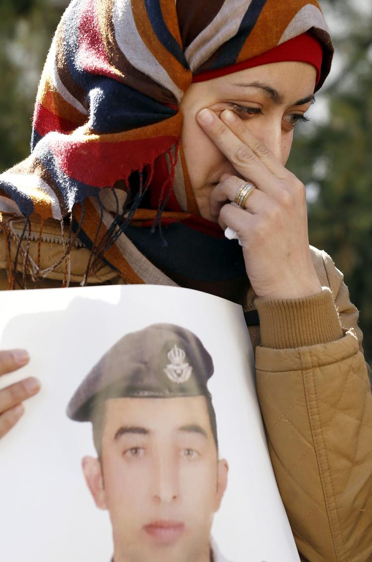 BRUTALT. En grædende kvinde holder et billede af den jordanske pilot, som på brutal vis blev brændt levende af Islamisk Stat. 