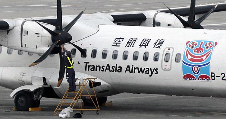 Eftertjek. En mekaniker gennemgår motoren på et af mTransAsia Airways' fly i Songshan Airport i Taipei, Taiwan. 