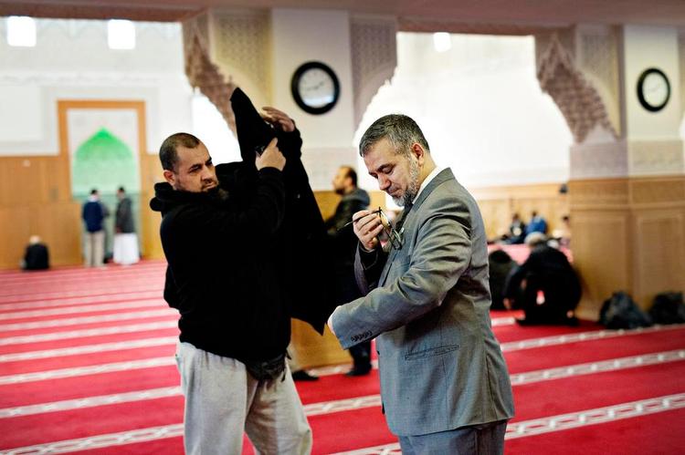 brobygger. Abdelhamid Hamdi (th.), der er formand for Dansk Islamisk Råd, har netop overstået fredagsbønnen (og får sin frakke tilbage). Rådet bliver af og til beskyldt for at være for danskervenligt af kritikere blandt fundamentalistiske muslimer. 