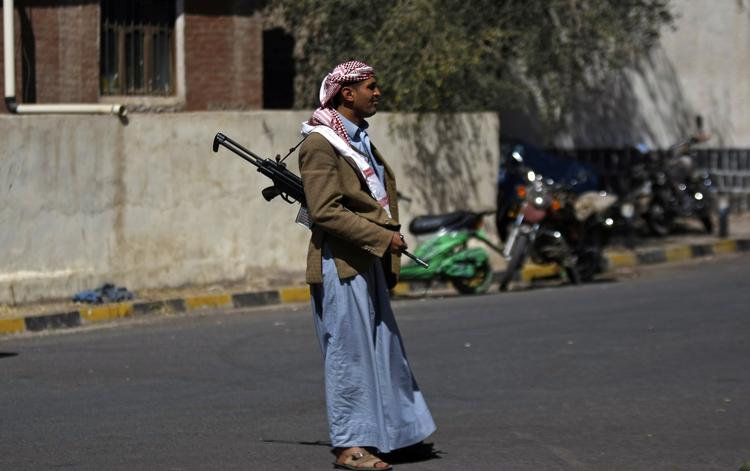 Magtkamp. En bevæbnet houthie står vagt uden for en regeringsbygning i Sanaa i Yemen i går. 
