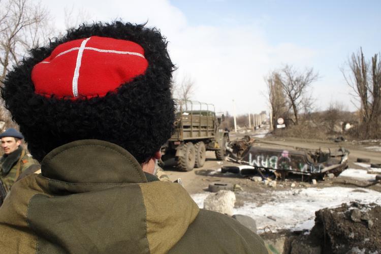 RUSSERMILITS. En kossak-kriger fra de russiskstøttede militser i Ukraine ser på resultaterne af en landminesprængning. Britiske politikere frygter, at Rusland nu vil fortsætte sin destabilisering i Baltikum. 