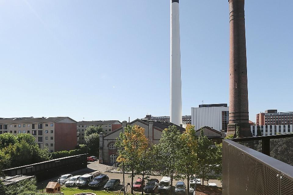 Nykløverets legeplads ligger med frit udsyn til Kedelhallen. Foto: Nykløveret/Rubow Arkitekter 