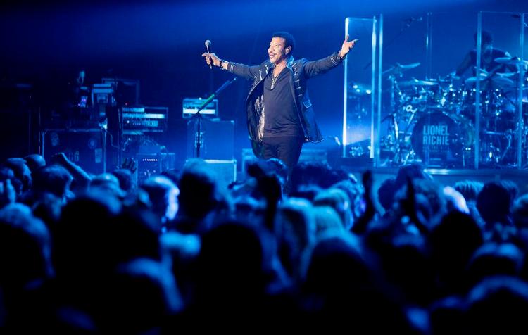 Selvtillid. Koncerten blev sat i gang af et rungende 'Hello', der fik et udspændt silkelagen til at falde foran Lionel Richie, som mødte sit jublende publikum med armene ude i frelserposition. 
