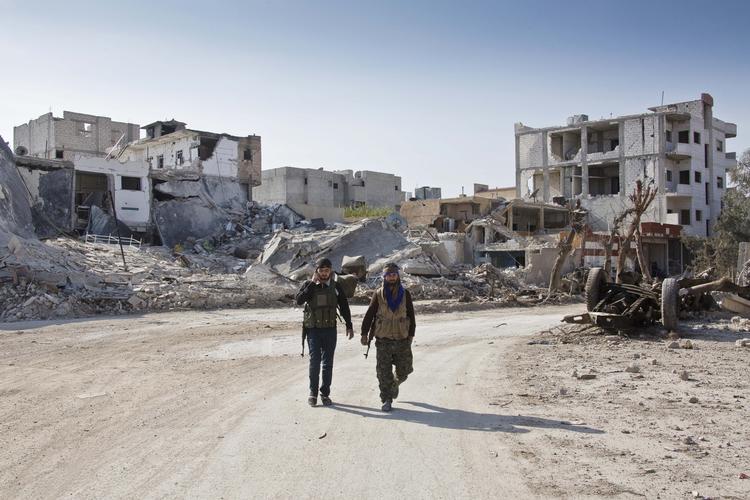 KONFLIKT. Kurdere spadserer gennem den sønderskudte by Kobane efter at den blev befriet fra den sunnimuslimske terrormilits Islamisk Stats belejring. Krigen i Syrien fylder meget i Amnesty Internationals årsrapport. 