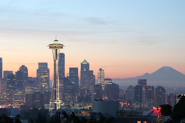 NÅLE. Det karakteristiske tårn 'Space Needle' pryder den amerikanske storby Seattles skyline. Th. ses bjerget Mount Rainer. 
