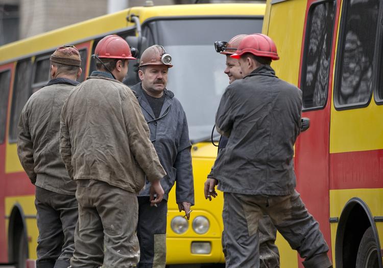 Uvished. Minearbejdere foran den mine i Ukraine, hvor et ukendt antal af deres kollegaer er fanget efter en eksplosion. 