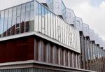 Veltilpasset. Huset er klart moderne, med meget store vinduesfelter på hjørnerne og i lejlighederne, men det er samtidig uden at være blevet det rene tilpasningsarkitektur virkelig godt tilpasset kvarteret. 