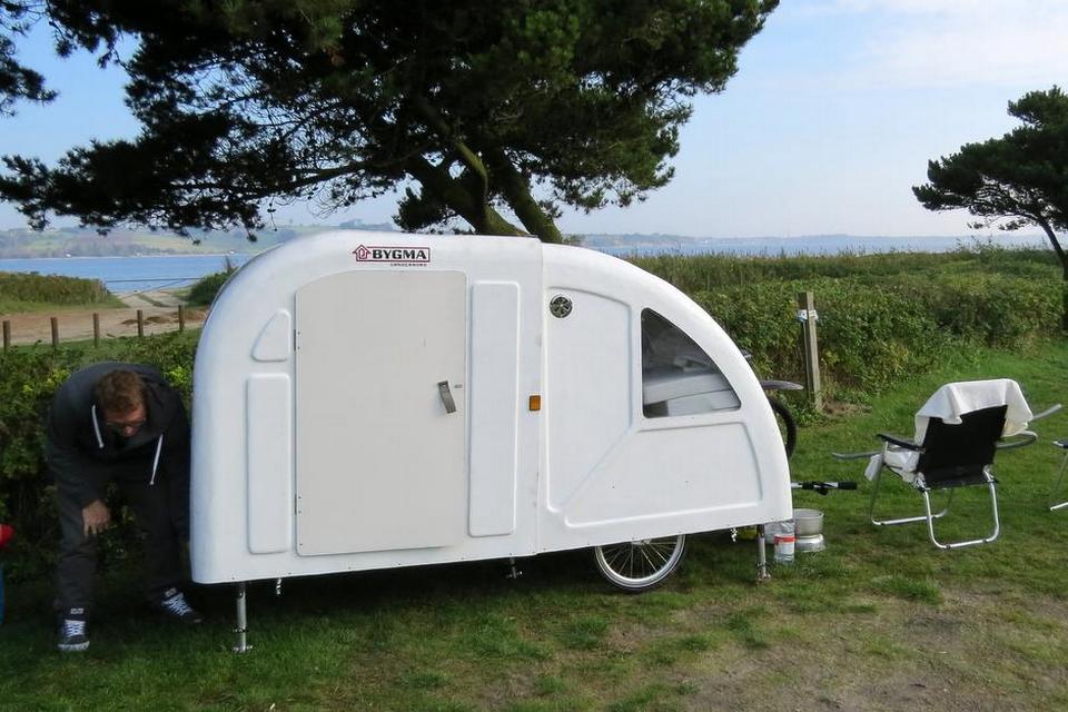 UDPAKNING. Den forreste del af vognene hives tilbage, og på den måde foldes campingvognen ud i længden. 