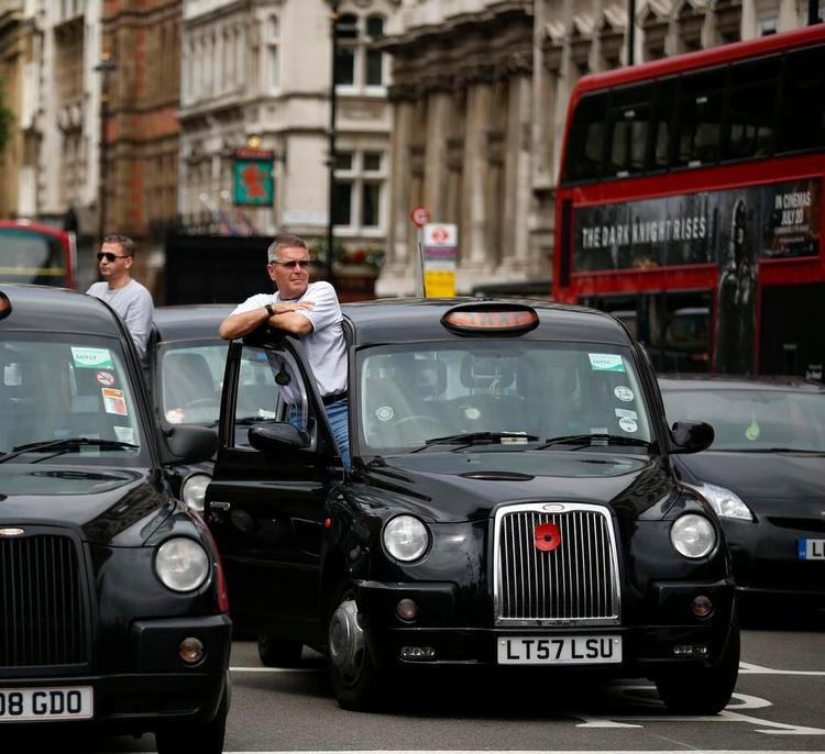 London taxi drivers park their cabs on the junction of Whitehall and Parliament Square, as they take part in a protest to jam traffic in reaction to not being allowed to use the Olympic driving lanes in London, Tuesday, July 17, 2012. (AP Photo/Matt Dunham) 