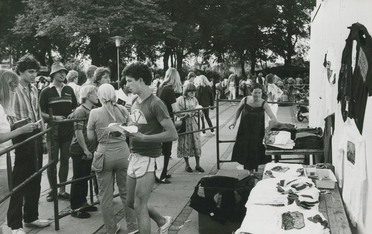 Dørene til stadion åbnede klokken 20, og der kom hurtigt pres på, da der kun var små bokse til at sluse folk igennem ind til deres pladser på betonrækkerne. Her ses en merchandisebod med t-shirts andre koncert-souvenirs. 