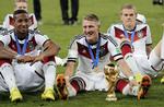 Præstationsløn. De tyske landsholdsspillere fik ved VM først bonus, da de havde kvalificeret sig til VM-kvartfinalerne. De - her Bastian Schweinsteiger med pokalen, Jerome Boateng (tv) og Matthias Ginter (th) – gik som bekendt hele vejen ved VM 2014. 