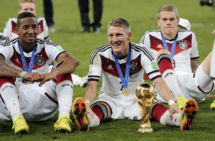 Præstationsløn. De tyske landsholdsspillere fik ved VM først bonus, da de havde kvalificeret sig til VM-kvartfinalerne. De - her Bastian Schweinsteiger med pokalen, Jerome Boateng (tv) og Matthias Ginter (th) – gik som bekendt hele vejen ved VM 2014. 