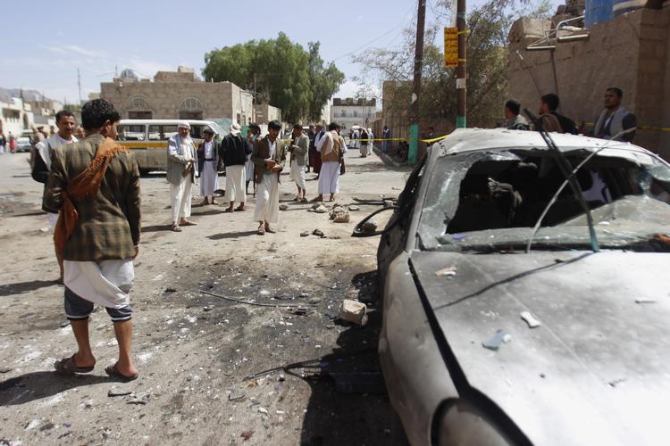 Oprøre fra Houthi-bevægelsen står ved en beskadiget bil umiddelbart efter at selvmordsbombere i fredags angreb to moskeer og dræbte over 140 personer. Foto: Hani Mohammed (AP Photo) 