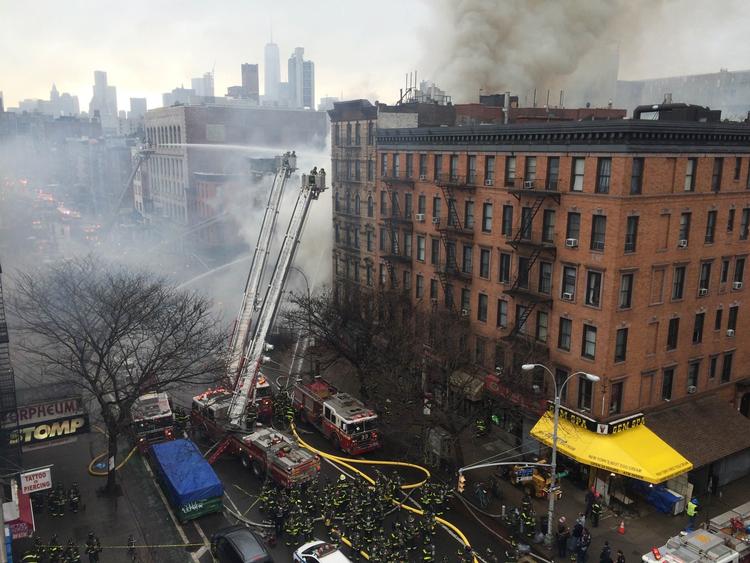 Brand. Røg stiger til vejrs over området, hvor en bygning i dag kollapsede. 