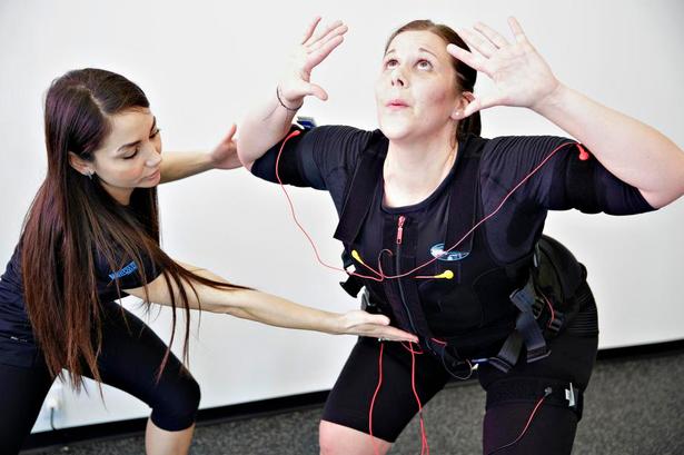 HØJSPÆNDT. Små elektriske impulser fra vest og bælter får Line Larsons muskler til at trække sig sammen, så de træner hårdere. Line driver EMS Bodypower i Odense. 