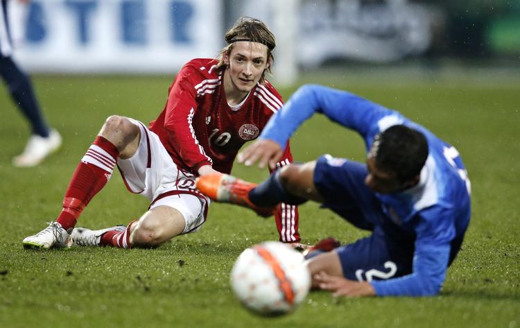 nærkamp. Rasmus Falk kigger langt efter bolden efter at være blevet tacklet af Juan Pablo Ocegueda fra USA. 