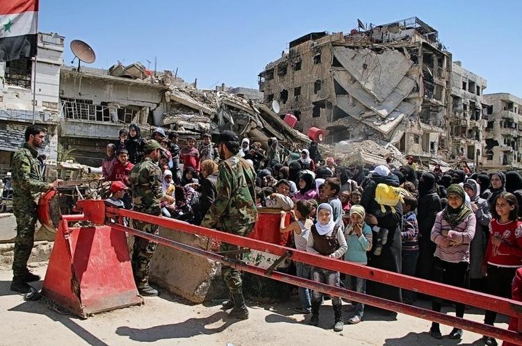Spærret. Syriske kontrolposter standser de få tilbageværende palæstinensere i flygtningelejren Yarmouk i Damaskus. De er nu på flugt fra IS' fremmarch i bydelen. 