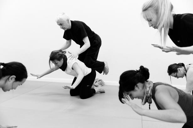 BØN. Tibetansk bedebevægelse med hænderne ud for ørerne. Siddende på en bedende partners rygstykker. 