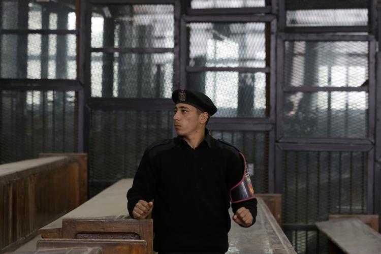 Farce. En egyptisk politimand foran buret der holder de anklagede i retssagen mod blandt andre den amerikanske statsborger, Mohammed Soltan. 