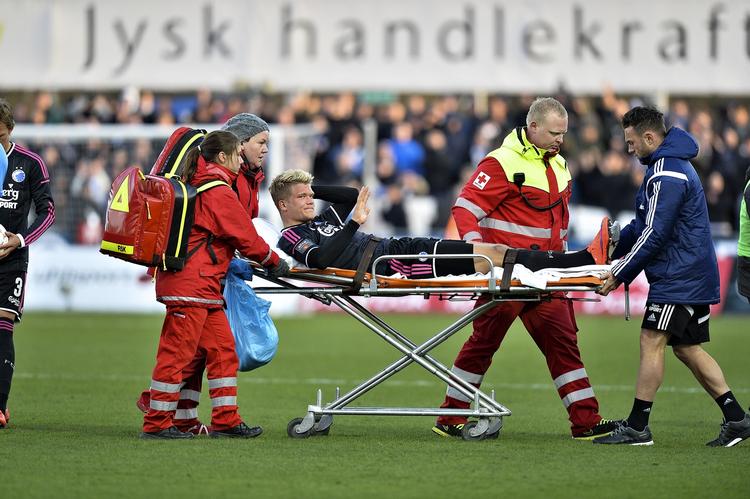 Pause. Andreas Cornelius havde åndsnærværelse nok til at vinke, da han blev kørt fra banen i Silkeborg med en brækket ankel. Angriberen er ude af spillet i et halvt år. 