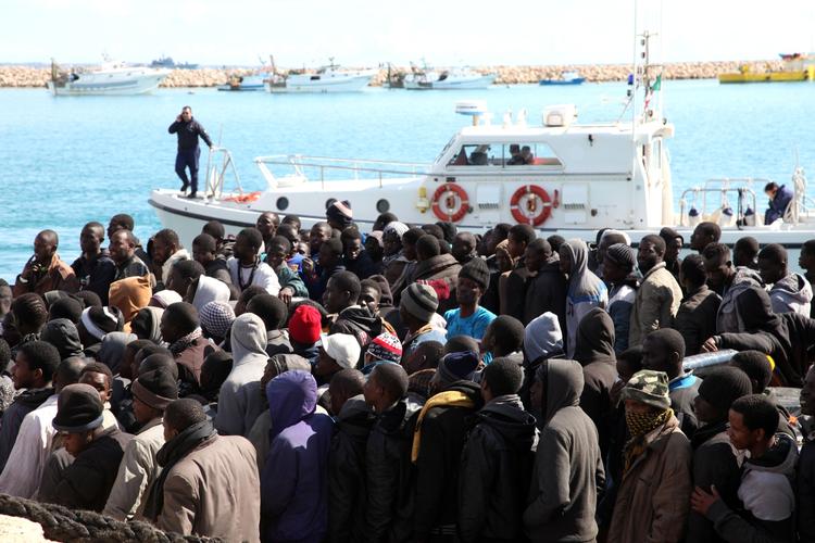ANKOMST. Migranter venter på at kunne forlade deres båd i havn på Sicilien. 