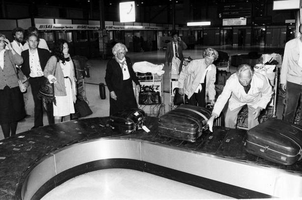 hjemme. Kufferterne ruller ind på bagagebåndet til de hjemkomne rejsende. I 1984 var der ikke nødvendigvis hjul på kufferterne. 