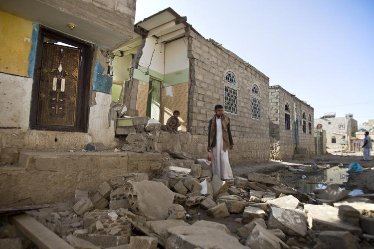 Luftangreb. En yemenit står foran sit ødelagte hus nær Sanaa Lufthavn. 